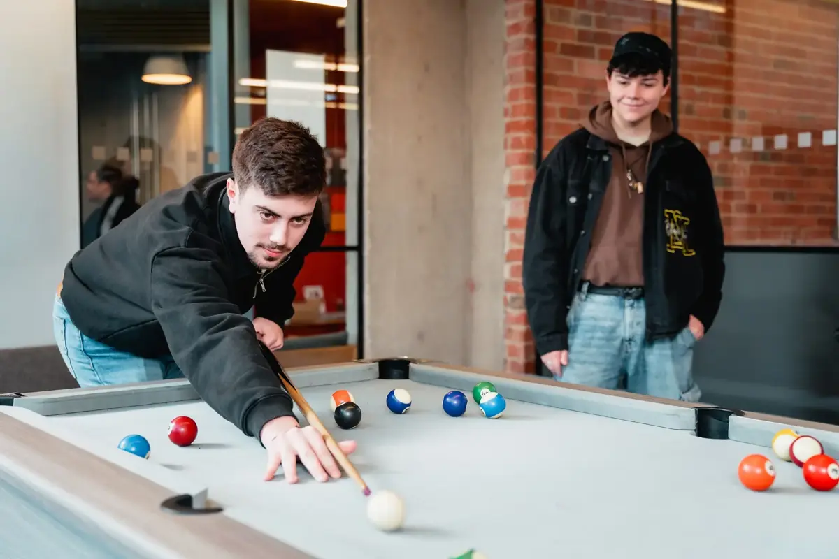 Two students playing pool