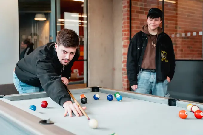 Two students playing pool